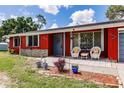 Cozy front porch with wicker chairs, gray front door, and landscaping at 20409 Emerald Ave, Port Charlotte, FL 33952