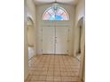 Bright foyer with tiled floor and arched window above double front doors, offering a welcoming entrance at 214 Castile Ct, Punta Gorda, FL 33983