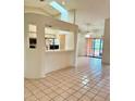 Open-concept living room with tiled floors, a bar counter to kitchen, and sliding glass doors to the lanai at 214 Castile Ct, Punta Gorda, FL 33983
