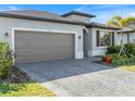 Beautiful one-story house boasts a spacious driveway, complemented by lush greenery and a modern design at 2161 Gardenia Ave, Port Charlotte, FL 33953