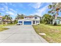 Charming two-story home with blue garage doors and shutters plus well maintained lawn at 2210 Mauritania Rd, Punta Gorda, FL 33983