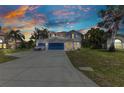 Inviting two-story home featuring blue garage doors and shutters under a colorful evening sky at 2210 Mauritania Rd, Punta Gorda, FL 33983