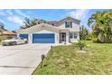 Charming two-story home with blue garage doors and shutters plus well maintained lawn at 2210 Mauritania Rd, Punta Gorda, FL 33983