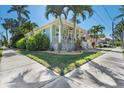 Charming coastal home with a welcoming porch, lush landscaping, and a vibrant turquoise exterior at 233 Durrance St, Punta Gorda, FL 33950