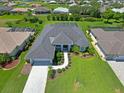 Aerial view of the house showcasing the lush landscaping, paved driveway, and meticulously maintained lawn at 260 Rotonda E Blvd, Rotonda West, FL 33947