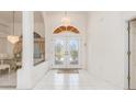 Elegant foyer with tile flooring, decorative lighting, and beautifully decorated glass front doors at 26090 Rampart Blvd, Punta Gorda, FL 33983