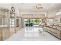 Bright living room with white tile floors, modern furniture, and sliding glass doors to lanai at 26090 Rampart Blvd, Punta Gorda, FL 33983