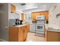 Functional kitchen with white appliances, wooden cabinetry and ample counter space for meal preparation at 311 Garvin St # 301B, Punta Gorda, FL 33950