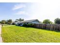 Charming single-story home with a well-maintained lawn and a wooden fence at 3270 Ithaca St, Port Charlotte, FL 33952