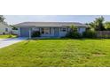 Well-kept home featuring a lovely front yard, tidy landscaping and neutral toned exterior paint at 3270 Ithaca St, Port Charlotte, FL 33952