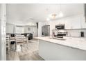 Bright, updated kitchen with white cabinets, stainless steel appliances, and an adjacent dining area at 3612 Patina Dr, Tampa, FL 33619