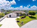 Well-manicured lawn complements this inviting single-story home with a two-car garage, mature landscaping, and charming curb appeal at 4142 Reif Ct, Port Charlotte, FL 33981