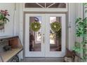 Elegant double front doors are adorned with decorative wreaths, creating a warm and inviting entrance to the home at 4142 Reif Ct, Port Charlotte, FL 33981