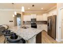 Modern kitchen featuring white cabinets, stainless steel appliances, and a granite island with seating at 4640 W Price Blvd, North Port, FL 34286