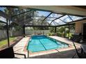 Private screened-in pool area with a waterfall feature, surrounded by lush landscaping at 4640 W Price Blvd, North Port, FL 34286