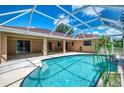 A covered pool area features a sparkling blue pool, patio area, and connection to the home's interior at 510 Border St, Port Charlotte, FL 33953