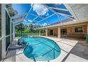 Screened-in lanai features a sparkling pool and outdoor living space adjacent to the home at 510 Border St, Port Charlotte, FL 33953