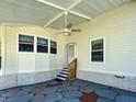 Covered carport featuring a ceiling fan, door to home, and a decorative stone-paved patio at 6562 Hikina Dr, North Port, FL 34287