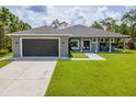 Well-maintained single-story home featuring a two-car garage and a lush, green lawn at 12300 El Prado Dr, Punta Gorda, FL 33955