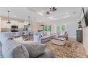 Open-concept living area with modern furnishings, wood floors, and seamless flow to kitchen at 12300 El Prado Dr, Punta Gorda, FL 33955