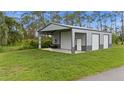 Large outbuilding with roll-up doors for workshop or storage; surrounded by green lawn at 12581 Eisenhower Dr, Port Charlotte, FL 33953
