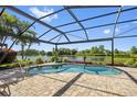 Enjoy outdoor living with this screened-in pool, offering a tranquil view of the lush backyard and serene lake at 13136 N Marsh Dr, Port Charlotte, FL 33953