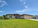 Attractive home with well-kept lawn, a three-car garage, and stone facade details at 15741 Autry Cir, Port Charlotte, FL 33981