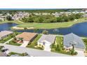 Aerial view of homes along a lake, featuring a golf course and water fountain at 1617 Britannia Blvd, Punta Gorda, FL 33980
