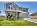 Charming two-story home with a well-manicured lawn, a covered porch, and an attached two-car garage at 16833 Terrapin Key Dr, Port Charlotte, FL 33953