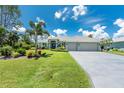 Charming one-story home featuring a well-kept lawn, lush landscaping, and a convenient three-car garage at 185 Hercules Dr, Rotonda West, FL 33947