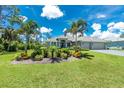 Attractive one-story home with verdant lawn and beautiful mature palm trees at 185 Hercules Dr, Rotonda West, FL 33947