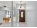 Bright foyer featuring a decorative front door, tiled floor, and modern pendant lighting at 1865 Rival Ter, North Port, FL 34286