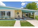 Close up of a charming covered porch with a rocking chair and well maintained lawn at 22341 Midway Blvd, Port Charlotte, FL 33952
