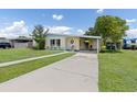 Beautiful yellow home featuring a lush green lawn and convenient carport at 22341 Midway Blvd, Port Charlotte, FL 33952