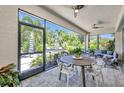 Covered lanai offering comfortable seating, a dining table, and serene views of the landscaped backyard at 25062 Palisade Rd, Punta Gorda, FL 33983