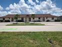 Charming multi-unit residence features a red tile roof, inviting arches, and is surrounded by lush greenery and palm trees at 2732 Magdalina Dr # C, Punta Gorda, FL 33950