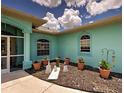 Charming front entrance with potted plants and garden decor accenting the turquoise exterior at 2969 Wells Ave, North Port, FL 34286