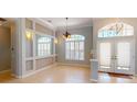 Living area featuring neutral paint, beautiful chandelier, archway, and plenty of light at 421 Marsh Creek Rd, Venice, FL 34292