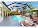 Relaxing screened-in pool area with comfortable lounge chairs and lush landscaping at 421 Marsh Creek Rd, Venice, FL 34292