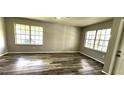 Open Living Room features wood-look floors and two large windows for lots of natural light at 426 Ricold Ter, Port Charlotte, FL 33954