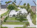 Stunning aerial view of waterfront home with pool, lush landscaping, and private docks on the river at 4460 Northshore Dr, Punta Gorda, FL 33980