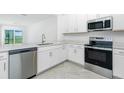 Modern kitchen with stainless steel appliances, stone countertops and white cabinets at 8706 Seasalt Loop, Englewood, FL 34224