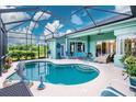 Beautiful screened-in pool area with comfortable outdoor seating and lush landscaping at 9954 Audrey St, Port Charlotte, FL 33981