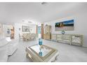 Open-concept living room and dining area with tiled floors, modern decor and plenty of natural light at 11383 Burgundy Dr, Venice, FL 34293