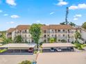 Three story condo building with covered parking, multiple balconies, and mature trees at 1144 Bird Bay Way # 102, Venice, FL 34285