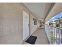 Hallway leading to the front door with a black welcome mat and clean exterior features at 1335 Mineo Dr # G, Punta Gorda, FL 33950