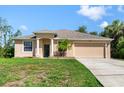 Charming single-story home with a well-maintained lawn, two-car garage, and welcoming curb appeal at 1693 Jagust Rd, North Port, FL 34288