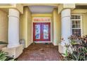 Elegant entrance showcasing stately columns, a red double door, and a brick pathway at 17188 Cape Horn Blvd, Punta Gorda, FL 33955