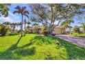 Inviting home with lush lawn, mature trees, colorful plants, and a brick driveway at 17188 Cape Horn Blvd, Punta Gorda, FL 33955