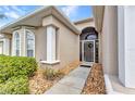Inviting entrance featuring a screened-in porch, decorative columns, and manicured landscaping at 24504 Buckingham Way, Punta Gorda, FL 33980